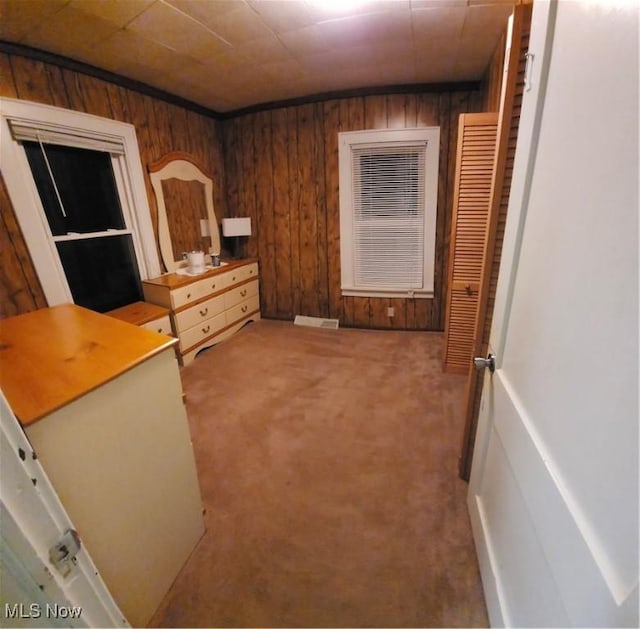 unfurnished bedroom with wooden walls and carpet