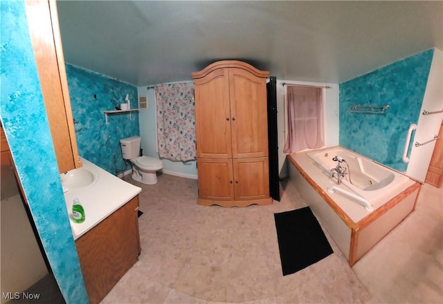 bathroom with vanity, a tub to relax in, and toilet