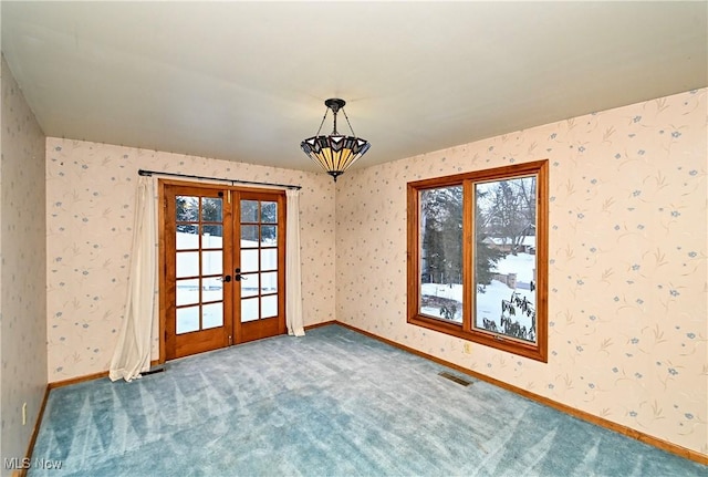 carpeted spare room with plenty of natural light and french doors