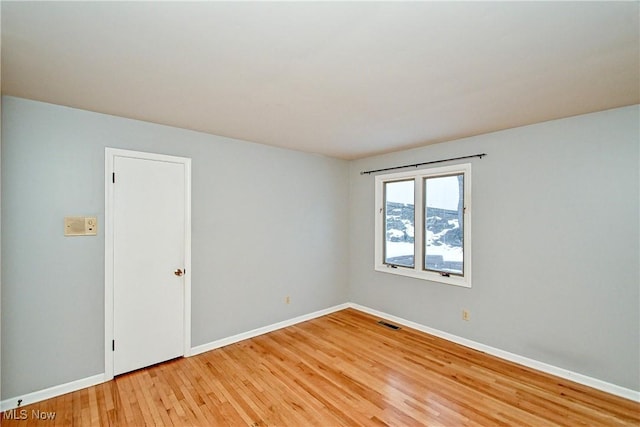 unfurnished room with hardwood / wood-style flooring