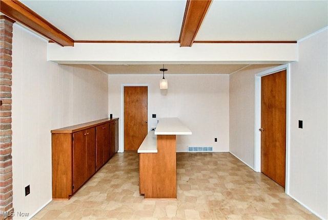 interior space with pendant lighting, beam ceiling, and kitchen peninsula