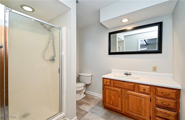 bathroom featuring walk in shower, vanity, and toilet