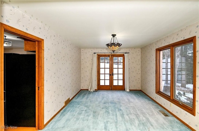 carpeted spare room with french doors