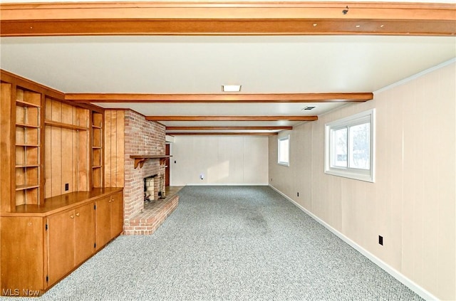 carpeted living room with beamed ceiling, ornamental molding, and a brick fireplace