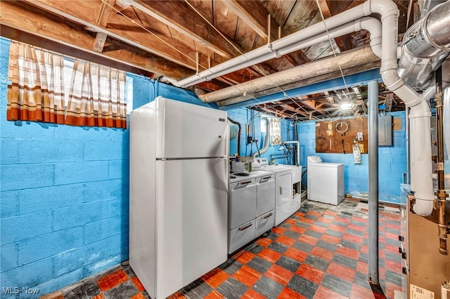 basement featuring independent washer and dryer, electric panel, and refrigerator