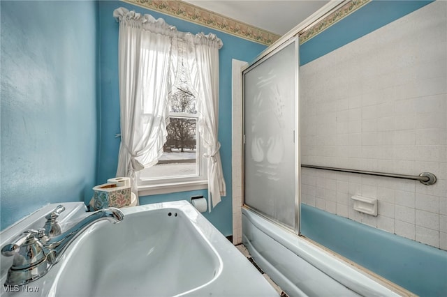 bathroom featuring sink and combined bath / shower with glass door