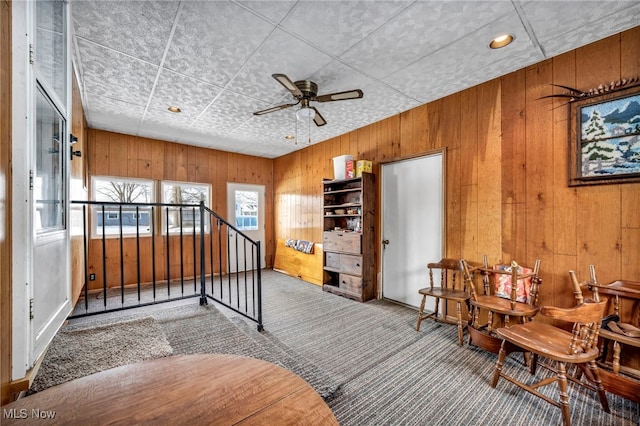 interior space featuring wooden walls and ceiling fan