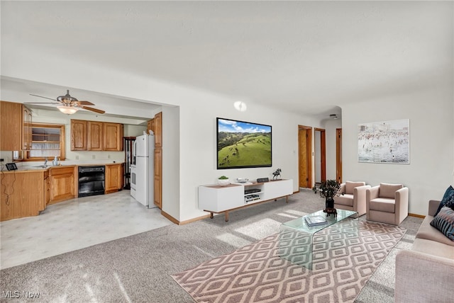 living room featuring sink, light colored carpet, beverage cooler, and ceiling fan