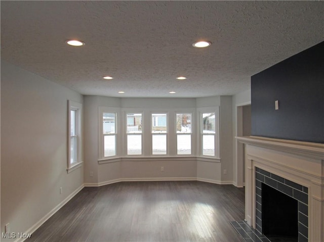 unfurnished living room with dark hardwood / wood-style flooring and a textured ceiling