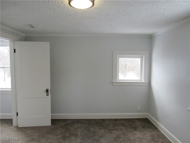 empty room with crown molding, a healthy amount of sunlight, and dark colored carpet