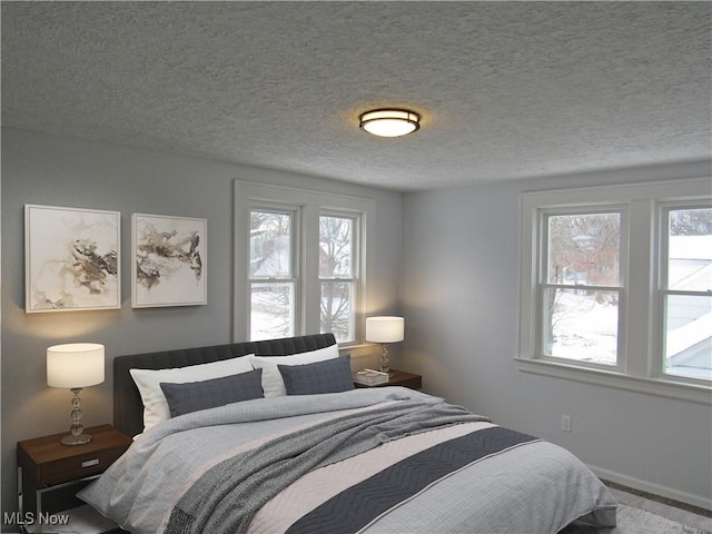 bedroom featuring multiple windows and a textured ceiling