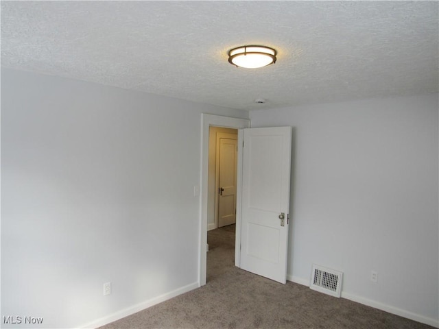 carpeted empty room with a textured ceiling