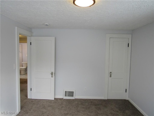 spare room with carpet flooring and a textured ceiling