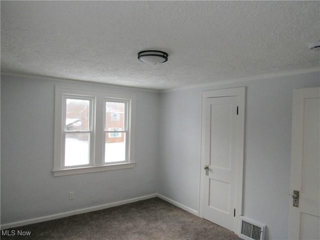 empty room with carpet flooring and a textured ceiling