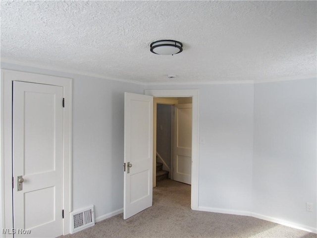 carpeted spare room featuring a textured ceiling