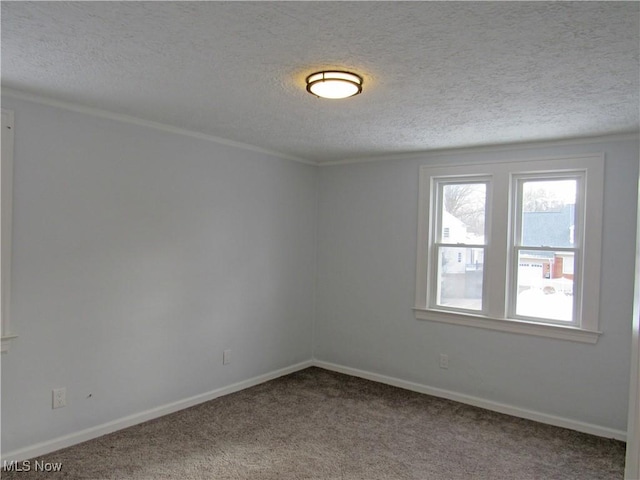 carpeted empty room featuring ornamental molding and a textured ceiling