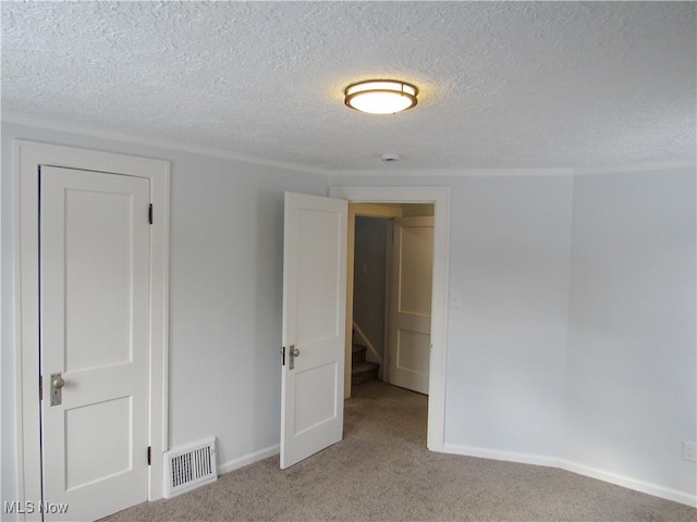 carpeted spare room featuring a textured ceiling