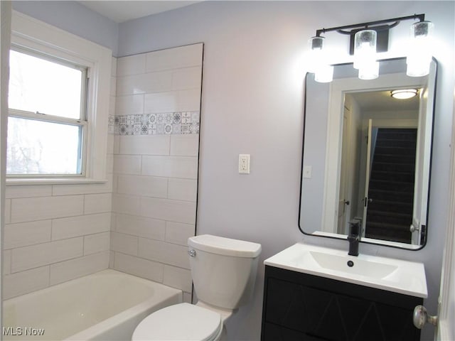 full bathroom with tiled shower / bath combo, vanity, and toilet