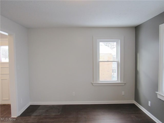 unfurnished room with plenty of natural light and dark hardwood / wood-style floors