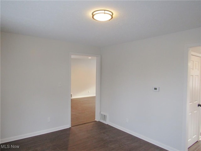 unfurnished room featuring dark hardwood / wood-style flooring