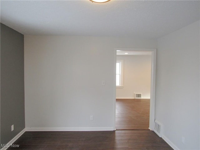 unfurnished room featuring dark hardwood / wood-style flooring