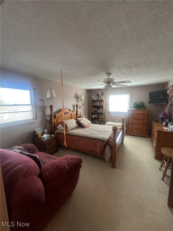 bedroom featuring carpet, a textured ceiling, and ceiling fan