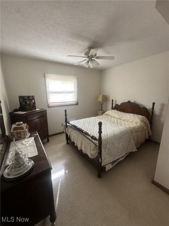 bedroom with ceiling fan and a textured ceiling