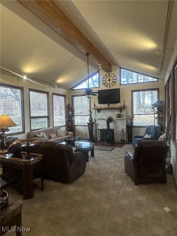 carpeted living room with lofted ceiling with beams and a wood stove