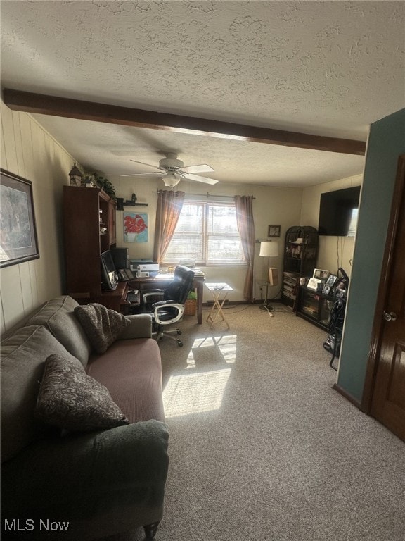 carpeted living room with beamed ceiling, ceiling fan, and a textured ceiling