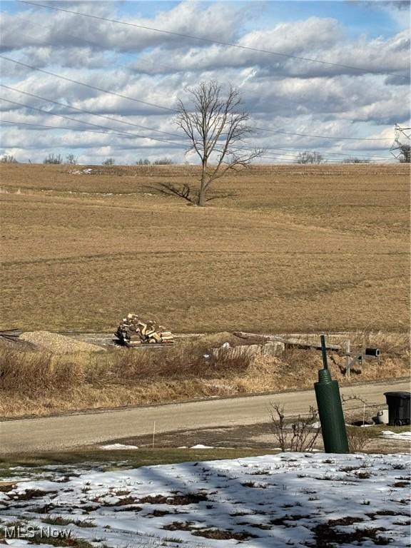 snowy yard featuring a rural view