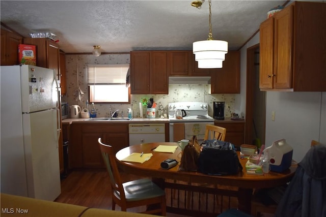 kitchen featuring range hood, decorative light fixtures, sink, white appliances, and a textured ceiling