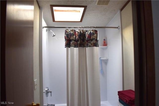 bathroom with a textured ceiling and shower / bath combo with shower curtain