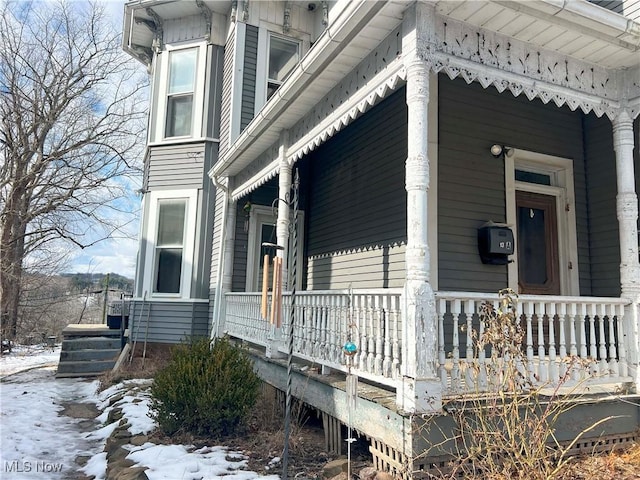 snow covered property featuring covered porch