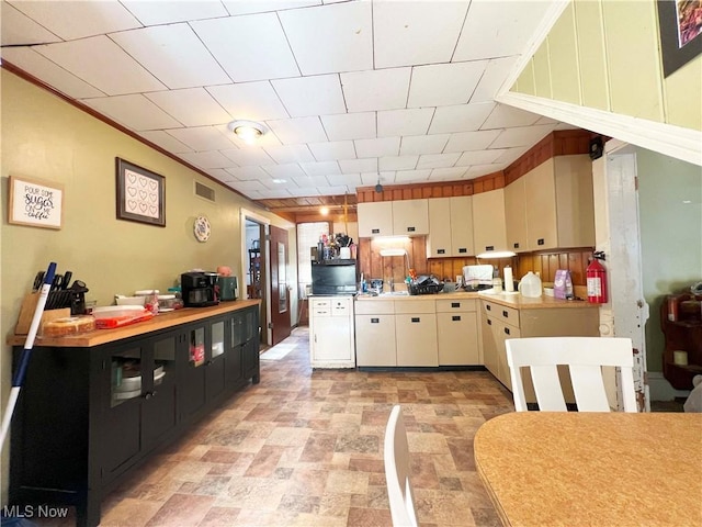 kitchen featuring crown molding and cream cabinetry