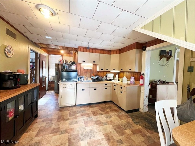 kitchen with stainless steel fridge and white cabinets