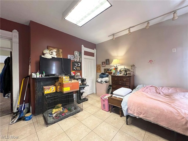 bedroom with track lighting and light tile patterned flooring