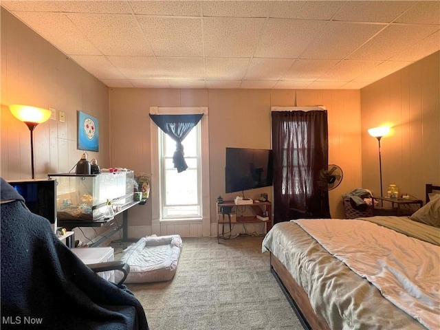 carpeted bedroom with wood walls