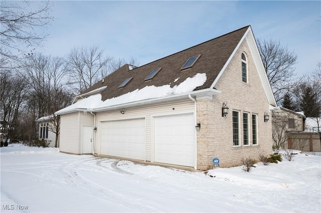 snow covered property featuring a garage