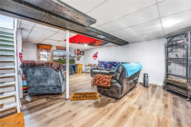 living room featuring a drop ceiling and hardwood / wood-style floors