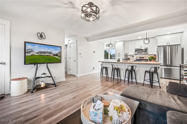 living room with sink and light hardwood / wood-style floors