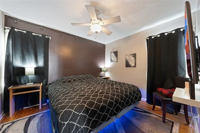 bedroom with dark hardwood / wood-style floors and ceiling fan