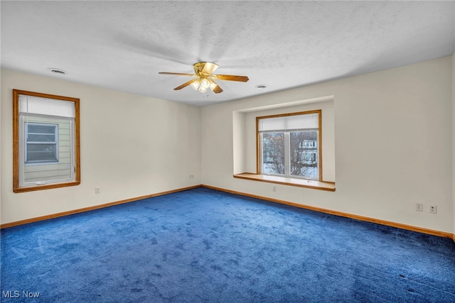 carpeted spare room with a textured ceiling and ceiling fan