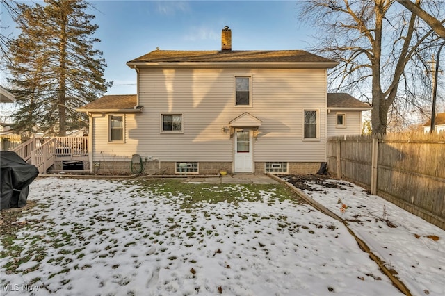 snow covered back of property featuring a wooden deck