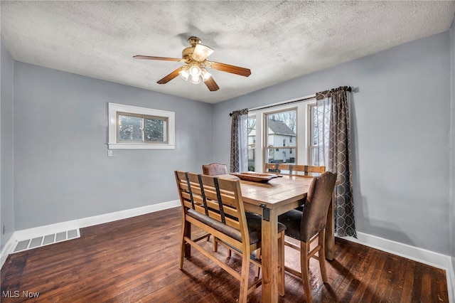 dining area featuring dark wood-type flooring, ceiling fan, and a textured ceiling