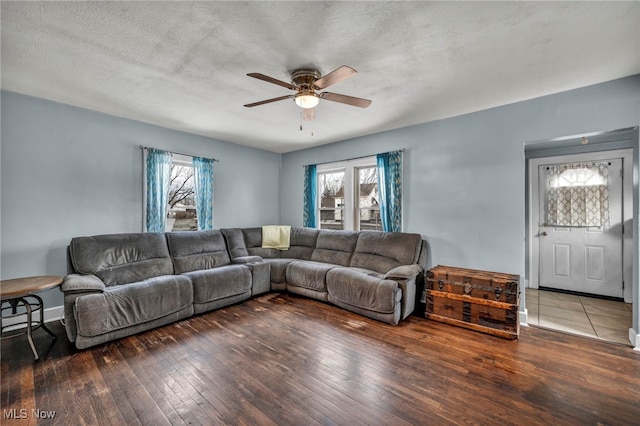 living room with dark hardwood / wood-style floors, a wealth of natural light, and a textured ceiling