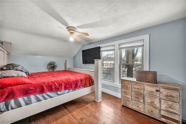 bedroom featuring wood-type flooring, a textured ceiling, vaulted ceiling, and ceiling fan