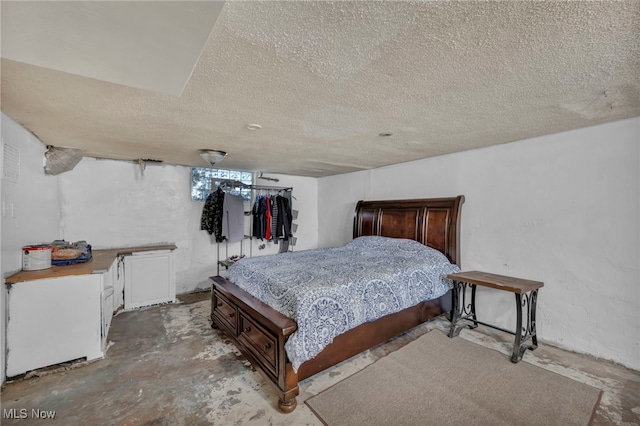 bedroom with concrete floors and a textured ceiling