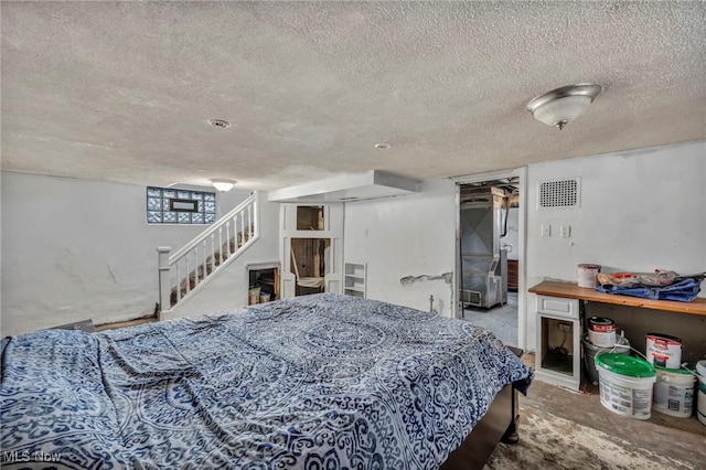 bedroom with concrete floors and a textured ceiling