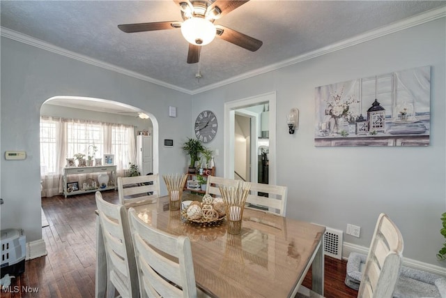 dining space with crown molding, dark hardwood / wood-style floors, ceiling fan, and a textured ceiling