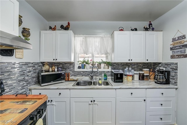 kitchen with white cabinetry, extractor fan, sink, and tasteful backsplash